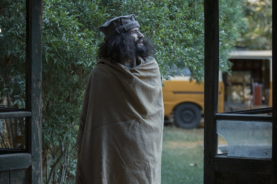 Man wrapped in a wool shawl outdoors