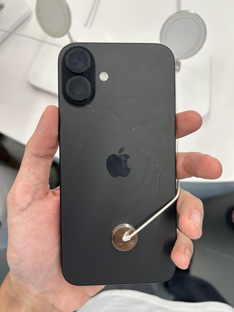 iPhone 16 Plus in black held in the hand, back view